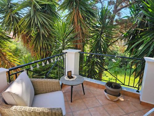 卡诺尼Corfu Villa Kanoni的阳台配有沙发和桌子,棕榈树