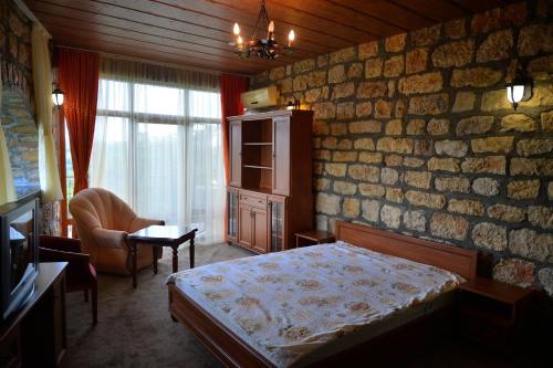 Комплекс Замъка的一间卧室设有一张床和石墙