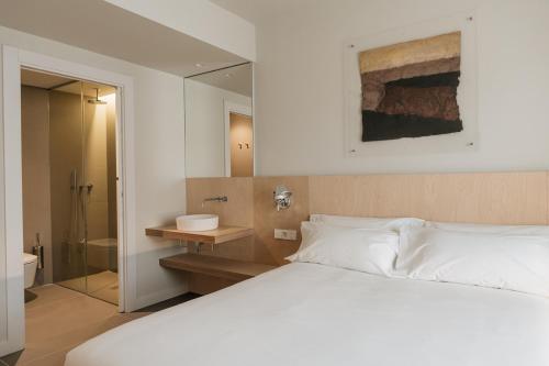 图德拉Hotel Santa Ana Tudela的一间带白色床的卧室和一间浴室