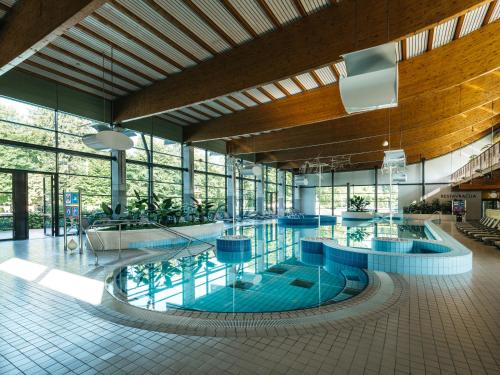 多莱尼斯凯托普利采克里斯塔尔酒店的一座大型游泳池,位于一座带窗户的建筑内