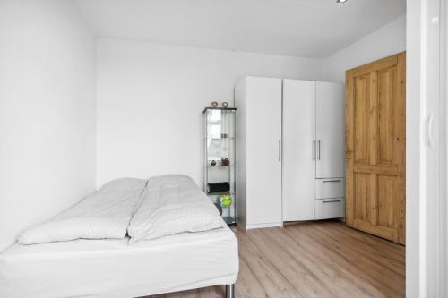 奥尔堡Lejlighed i hjertet af Aalborg的一间白色卧室,配有一张床和一个衣柜