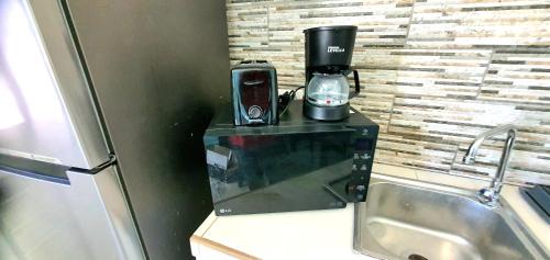 奥拉涅斯塔德BUSHWA APARTMENTS #2 , Tu 5 estrellas的咖啡壶,位于水槽旁的柜台上方