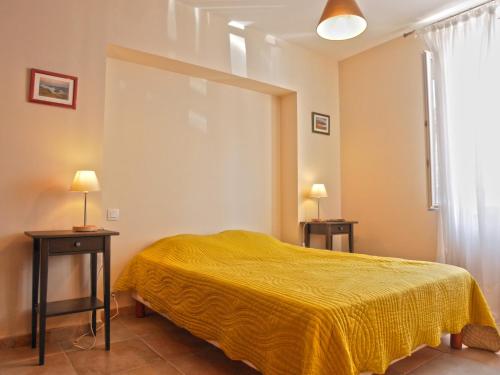 勒帕莱Appartement Le Palais, 2 pièces, 3 personnes - FR-1-418-95的一间卧室配有黄色的床和两张桌子
