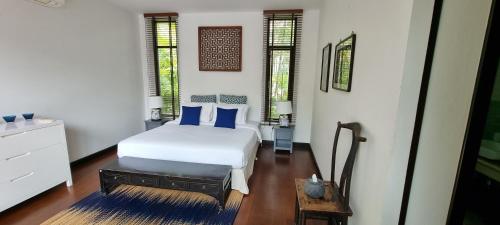 邦涛海滩Beautiful villa walking distance from Bangtao Beach的一间卧室配有白色床和蓝色枕头