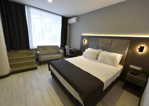 图兹拉Sahil Hotel Pendik的酒店客房带一张大床和一把椅子