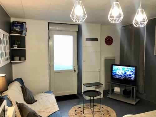 普吕维涅La voyageuse, gîte 6 places的客厅配有沙发、电视和灯。