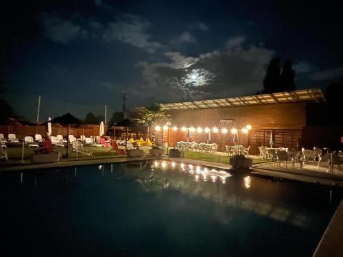 水晶湾Hotel Santo Stefano的夜间游泳池,月亮为背景
