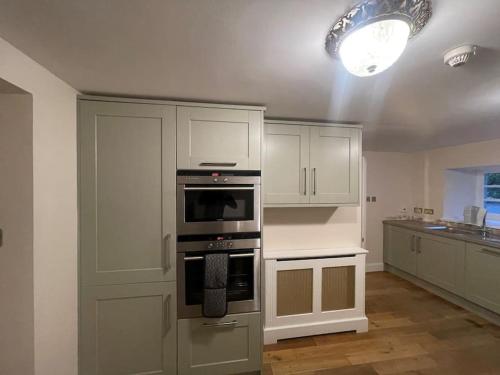 爱丁堡Castle Gogar Cottage的厨房配有白色橱柜和烤箱。