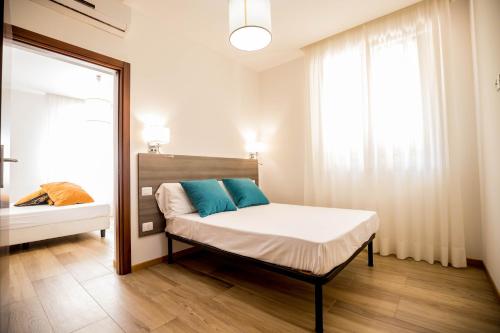 斯波莱托RESIDENCE VILLA TOTA的一间卧室配有一张带蓝色枕头的床和一扇窗户。
