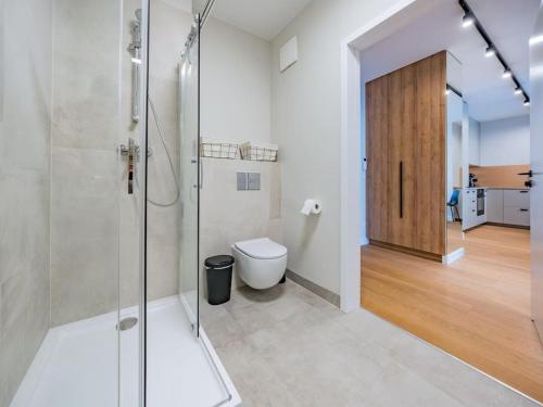 格但斯克Hello Apartments RIO with private parking的一间带玻璃淋浴和卫生间的浴室