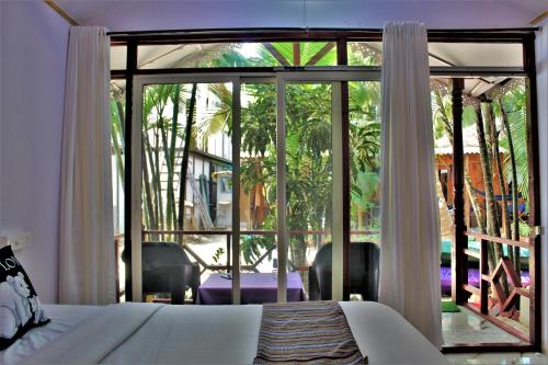 卡纳科纳Sai Valentines的一间卧室设有一张床和一个大型玻璃窗