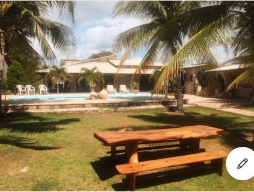 盖比姆Casa LUXO Guaibim的游泳池旁草地上的野餐桌