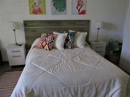 迈普Habitación doble, baño privado.的一间卧室配有一张带2个床头柜的大床