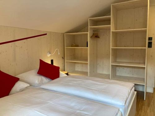 WeissbachHorská chata Smědava的卧室配有白色的床、红色枕头和架子