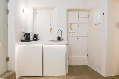 弗通Naos Suites的厨房配有白色橱柜和水槽