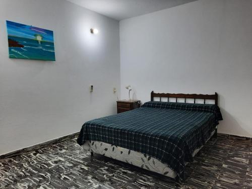 科连特斯DEPARTAMENTO COSTA PLANTA ALTA的卧室配有一张床,墙上挂有绘画作品