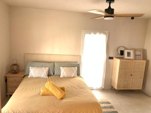 托雷德本纳贾尔邦Villa AURA 500 metros de la playa的一间卧室配有一张带两张黄色毛巾的床