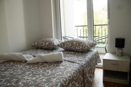 VrnjciVasilije的卧室配有带枕头的床铺和窗户。