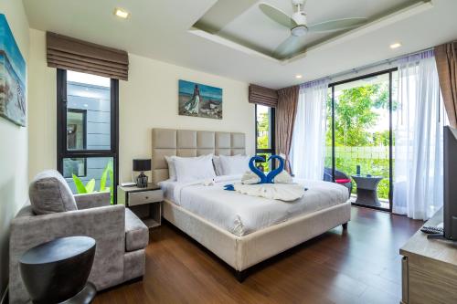 邦涛海滩Laguna Park Villa with rooftop pool by Lofty的卧室配有床、椅子和窗户。