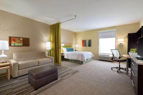 WetheringtonHome2 Suites by Hilton Cincinnati Liberty Township的酒店客房,配有床和沙发