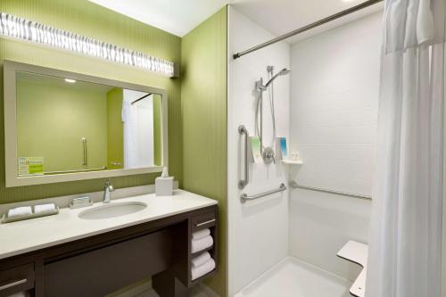 WetheringtonHome2 Suites by Hilton Cincinnati Liberty Township的浴室配有盥洗盆和带镜子的淋浴