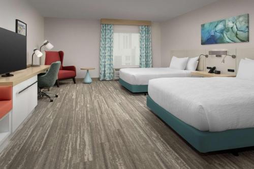 奥兰多Hilton Garden Inn Orlando Downtown的酒店客房设有两张床和一台平面电视。