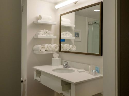 绿湾汉普顿格林湾市中心酒店 的浴室配有盥洗盆、镜子和毛巾