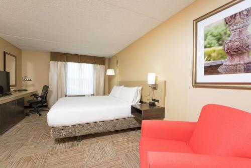 拉法叶拉斐特瓦巴什兰丁希尔顿花园酒店的酒店客房,配有一张床和一张红色的沙发