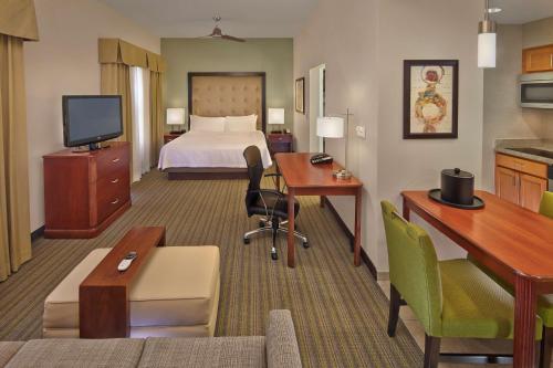 代托纳海滩希尔顿惠庭套房酒店 - 戴托纳海滩快道-机场的配有一张床和一张书桌的酒店客房