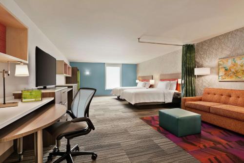 银泉Home2 Suites By Hilton Silver Spring的配有一张床和一张书桌的酒店客房