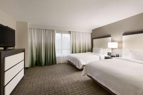 纽瓦克纽瓦克威明顿南大使套房酒店的酒店客房设有两张床和一台平面电视。