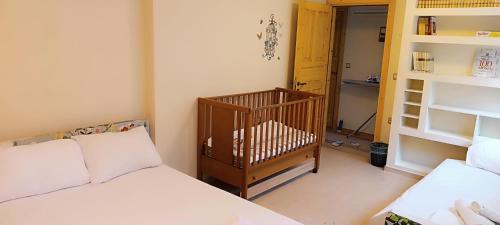 亚历山德鲁波利斯Villa Elli的一间卧室配有两张床和一张婴儿床。
