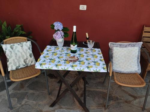 San AndrésCasa Rural Amapola的一张桌子、两把椅子和一瓶葡萄酒