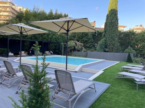 佛罗伦萨MH佛罗伦萨酒店及水疗中心的庭院内一个带椅子和遮阳伞的游泳池