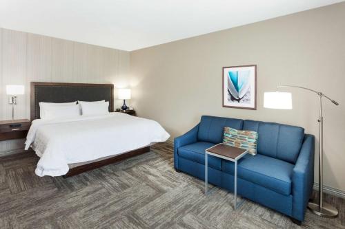 肯纳邦克Hampton Inn Kennebunk Kennebunkport Me的酒店客房,配有床和蓝色的沙发