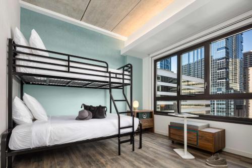 费城Motto by Hilton Philadelphia Rittenhouse Square的一间卧室设有一张双层床和大窗户。