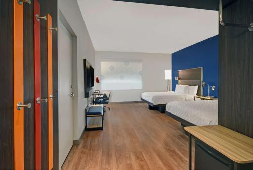 特洛伊Tru By Hilton Troy Detroit, Mi的酒店客房带两张床和一张桌子以及椅子。