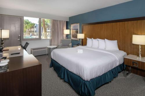 杰克逊维尔杰克逊维尔机场希尔顿逸林酒店的酒店客房设有一张大床和一张书桌。
