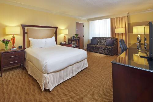 罗利罗利北山希尔顿酒店的大型酒店客房,配有床和沙发