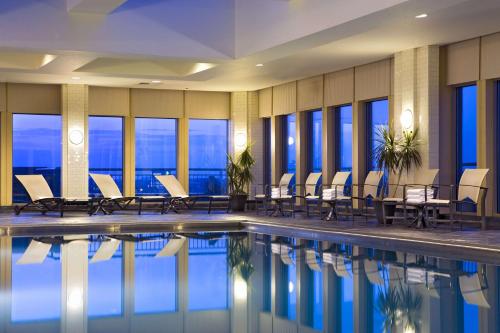 费城宾州兰丁希尔顿费城酒店的酒店游泳池设有桌椅和窗户。