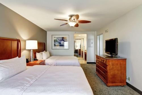 罗杰斯汉普顿本顿维尔 - 罗杰斯豪伍德套房酒店的一间卧室配有两张床和一台平面电视