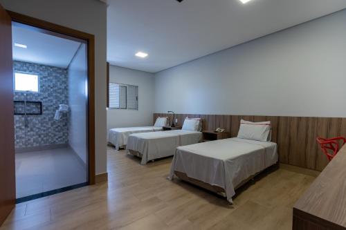 戈亚尼亚里约韦尔梅洛酒店的酒店客房设有两张床和窗户。