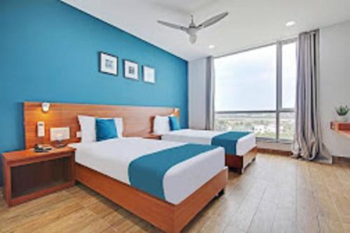 钦奈DSquare- OMR的一间卧室设有两张床和蓝色的墙壁
