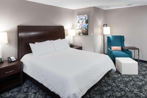 梅森辛辛那提/马森希尔顿花园酒店的酒店客房,配有一张床和一张蓝色椅子