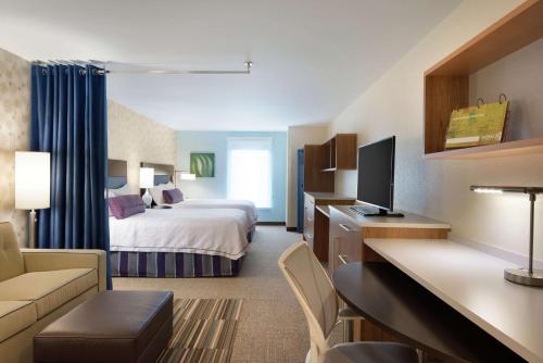 密尔沃基密尔沃基机场希尔顿欣庭套房酒店的酒店客房设有床和客厅。