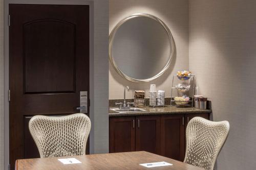 俄克拉何马城俄克拉荷马城布里克汉普顿套房酒店的一间带桌子和镜子的用餐室