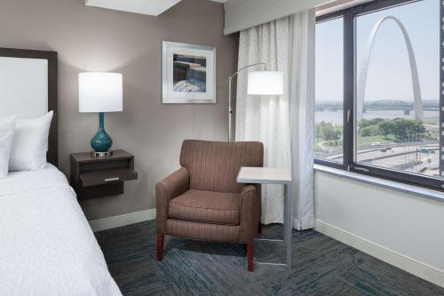 圣路易斯圣路易斯拱门希尔顿恒庭酒店的卧室配有床、椅子和窗户。