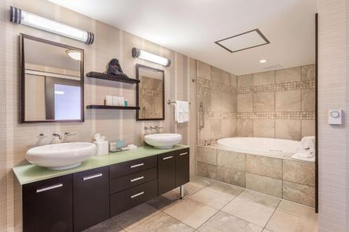麦迪逊汉普顿麦迪逊市中心套房及酒店的浴室配有两个盥洗盆和浴缸。