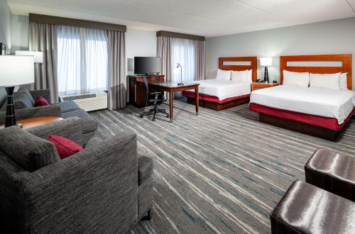 圣路易斯圣路易斯森林公园汉普顿酒店及套房的酒店客房,设有两张床和一张沙发