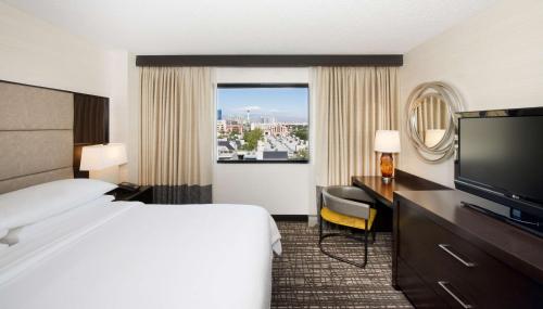 拉斯维加斯Embassy Suites by Hilton Las Vegas的配有一张床和一台平面电视的酒店客房